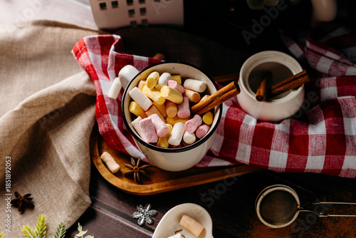 Winter still life with cocoa, cookies and cinnamon on festive textile. Cozy holiday food scene and warm rustic atmosphere.