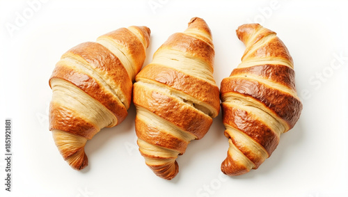 Three flaky croissants on white surface. Top view