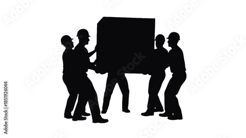 Four workers in hard hats moving large box in teamwork