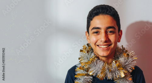 Smiling young man wearing festive tinsel during holiday celebration  
