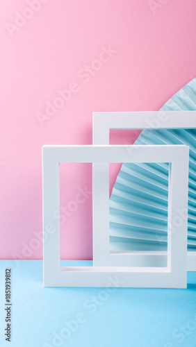 White frames with blue paper fan against pink and blue background showcasing modern design