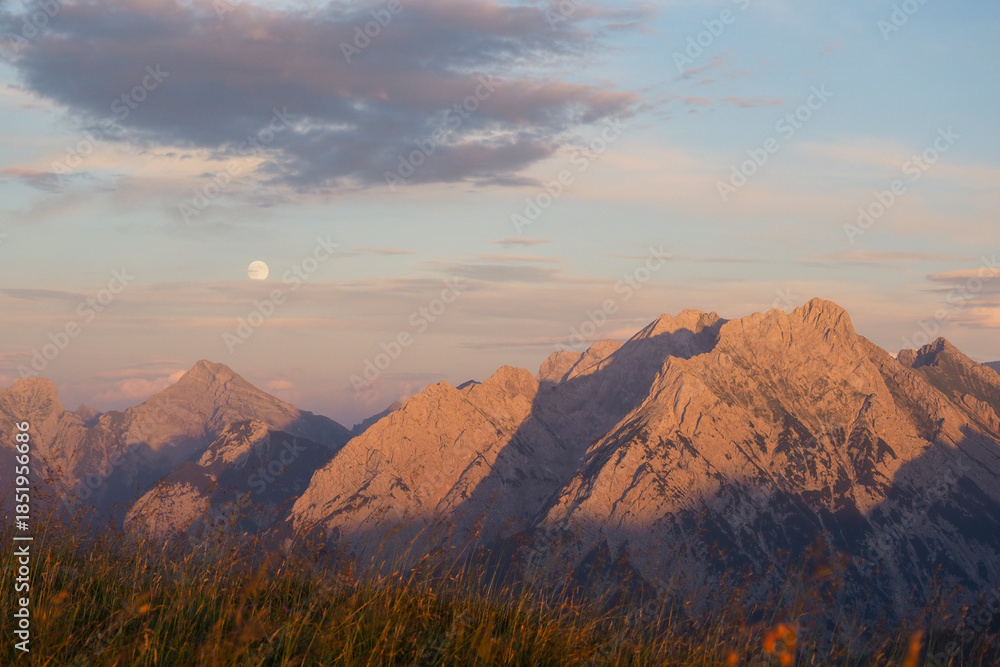 Fototapeta premium Spectacular sunset over the Karwendel mountains, with glowing peaks and dramatic alpine light.