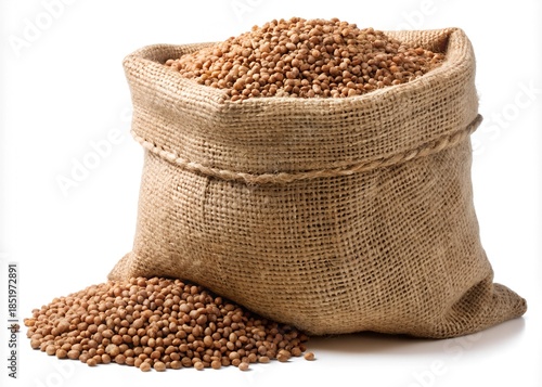 A full burlap sack overflowing with small, round, brown grains isolated on white background