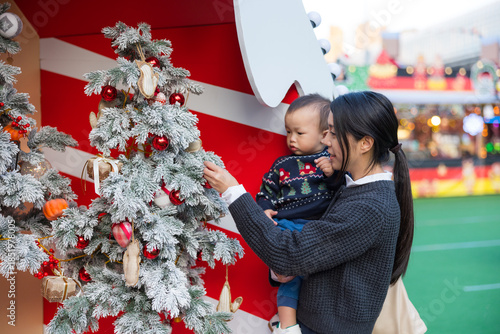 Wallpaper Mural Mum walking with her baby at Christmas market with tree decoration Torontodigital.ca