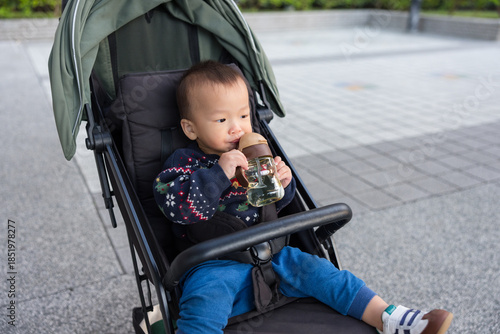 Wallpaper Mural Baby drinking water while sitting on stroller Torontodigital.ca