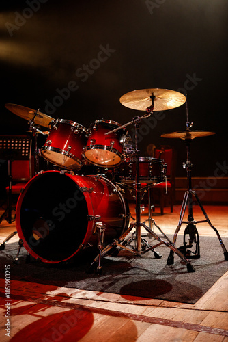 Front view of red acoustic drum set on stage