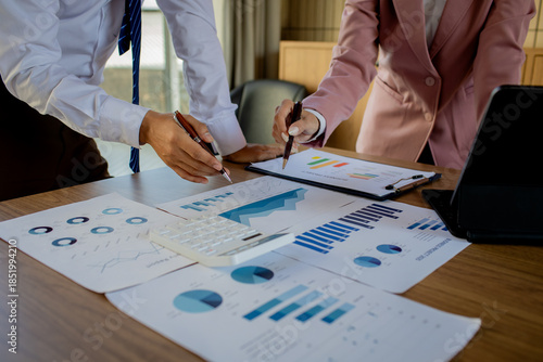 A professional female accountant sits at a desk, carefully examining legal paperwork and auditing financial records to finalize an important deal.