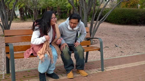 Asian couple sitting on a park bench during a saint valentine´s day date