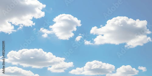 White fluffy cumulus clouds drift peacefully across a bright blue sky on a clear day isolated on white background