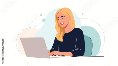 Happy young blonde woman working or studying from home, smiling as she types on her laptop computer at a modern desk setup.