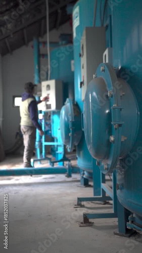 Technician Operating Control Panel in Modern Water Pumping Station.