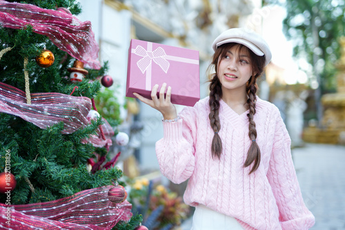  During Christmas time, a happy young woman enjoys a large Christmas gift.
