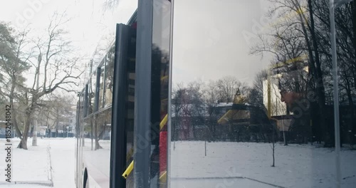 Side view of passengers getting off bus. Bus stopping, door opening, baby stroller sign on window, girl gift box holding, boy in glasses, old man. Concept of everyday routine,