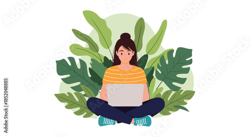 Young woman sitting cross legged and working on a laptop surrounded by large green tropical monstera and palm leaves.