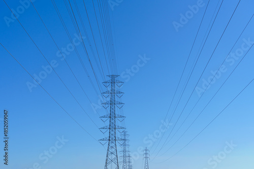 High-voltage power poles supplying electricity to the city, with the sky as a backdrop.