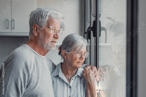Anxious scared elderly couple embracing, facing troubles together. Family love, senior years in trust, health issue, mutual support empathy in crisis, wife consoling thoughtful husband look out window