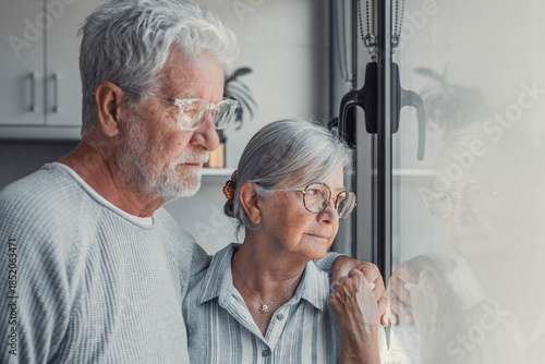 Anxious scared elderly couple embracing, facing troubles together. Family love, senior years in trust, health issue, mutual support empathy in crisis, wife consoling thoughtful husband look out window