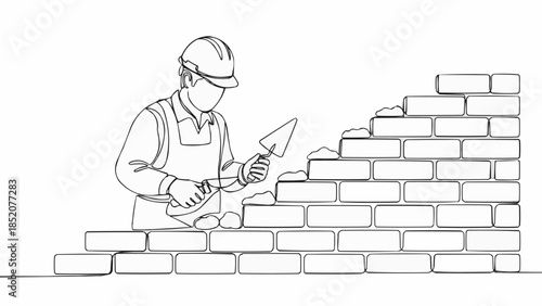 Construction worker building a brick wall with trowel.