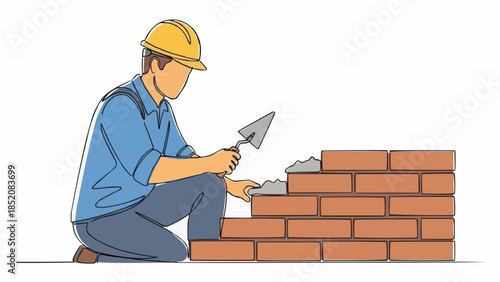 Construction worker building a brick wall with trowel.