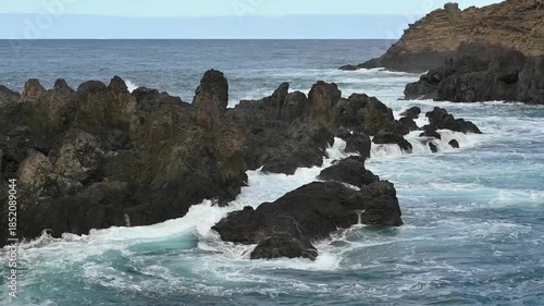 Waves of the Atlantic ocean splashing onto rocks on the coast of Porto Moniz, Madeira, Portugal