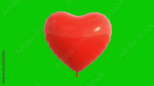 Red Heart Shaped Balloon on Green Background.