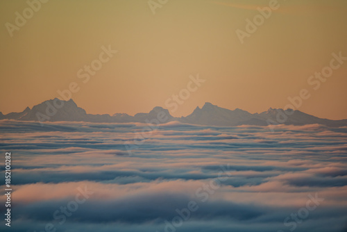 Berglandschaft mit Wolken und Sonnenaufgang über den Gipfeln in der Dämmerung