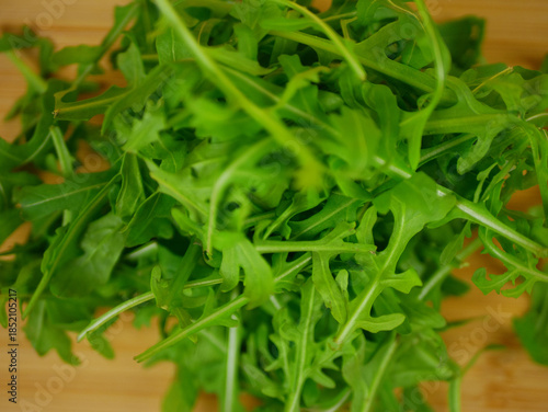 Wallpaper Mural Fresh green arugula piled on a wooden board in a clean ingredient closeup for salad preparation and healthy food visuals, high quality pro photo Torontodigital.ca