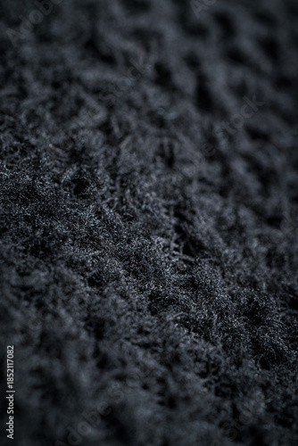 The fabric of black fleece, a synthetic knit with a soft, fluffy texture