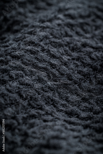 The texture of a soft black fleece fabric with visible fibers and folds