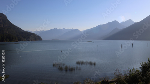 Hazy morning on lake between mountain ridges