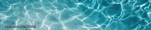 Top view of crystal clear azure water surface with soft ripples and sunlight reflections. Swimming pool or tropical sea texture background banner