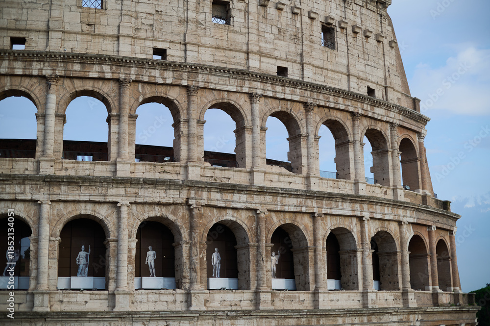 Obraz premium The iconic Roman Colosseum at sunset featuring the ancient stone arches and monumental architecture of the historic Flavian Amphitheatre in Rome Italy