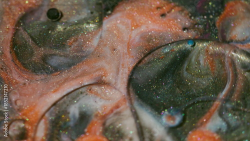 Shimmer ink. Vibrant bubbles. Defocused orange yellow red color oil water sparkling flow floating on abstract acrylic art background.