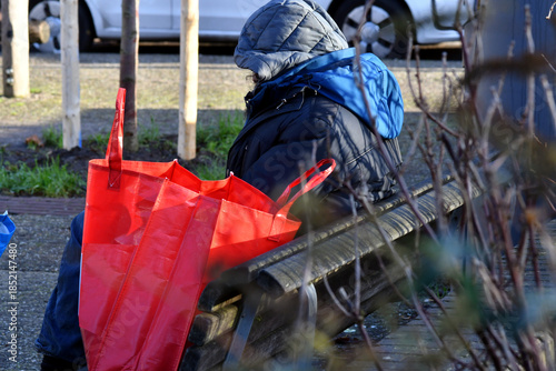 Un senzatetto in città seduto sulla panchina in inverno