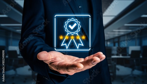 Man holds a digital symbol of a badge with stars in an office setting showing quality and achievement during daytime hours