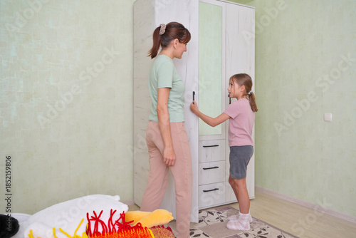 Mother and daughter sorting clothes in a cozy room.