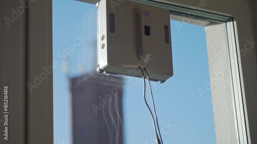 Close up of automatic window cleaning robot. Robotic window cleaner washing glass at home. Concept of smart home appliances