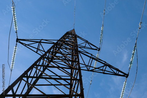 High-voltage power transmission tower against blue sky