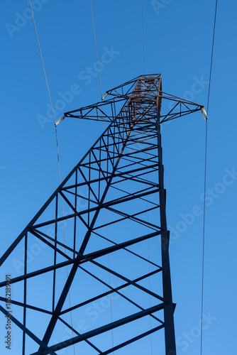 High-voltage power transmission tower against blue sky