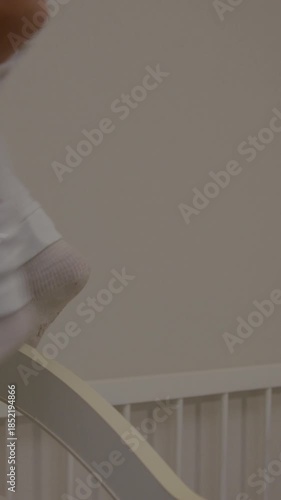 Baby joyfully engaging with caregiver in crib, showcasing playful interaction and emotional connection, camera pans and zooms in for intimate moments