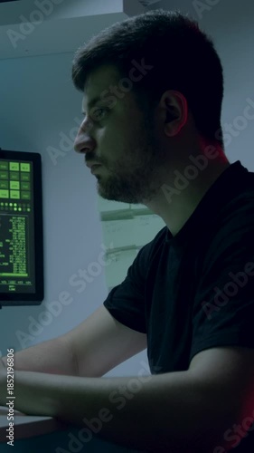 African American man, an artificial intelligence engineer, is deeply focused on coding at his workstation, with multiple screens displaying data, camera pans and zooms in on his actions