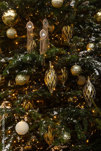 Christmas tree decorated with gold ornaments and snow. Vertical New Year's banner. Selective focus