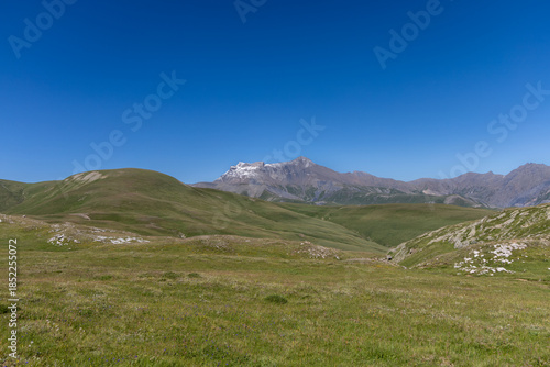 Mountain view of the Emparis Plateau in the Arves Massif, Hautes-Alpes, French Alps, featuring rugged peaks and alpine meadows.