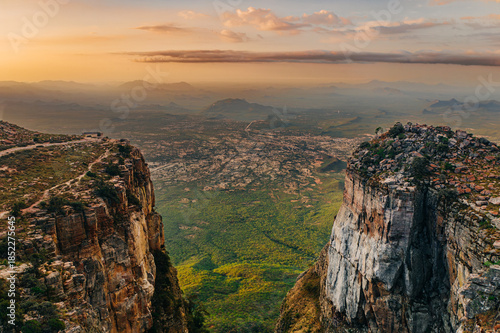 Photos Aerial view of a dramatic escarpment and valley at sunset, with steep cliffs, vast plains, and distant mountains, overlooking the Tundavala Gap from Serra da Leba in Huíla Province, Angola