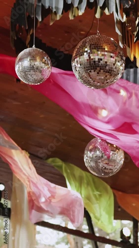Vertical video. Disco balls. Party or wedding decor, festive lighting and fabric decorations, festive atmosphere with lights.