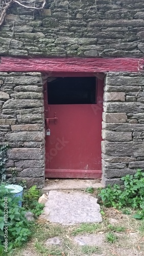 Porte rouge rustique dans un bâtiment en pierre