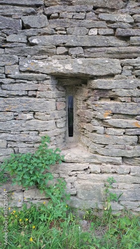 Fenêtre verticale ancienne dans un mur en pierre