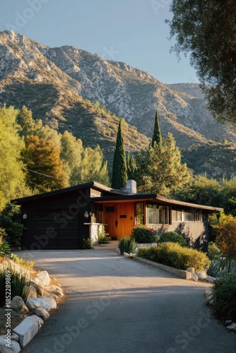 Modern house surrounded by trees and mountains in the afternoon sun, featuring a driveway and garden, located in a quiet neighborhood