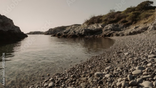 Serene Rocky Cove with Calm Waters and Distant Hills.