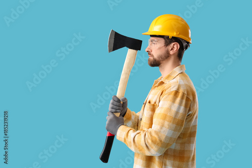 Male worker with ax on blue...
